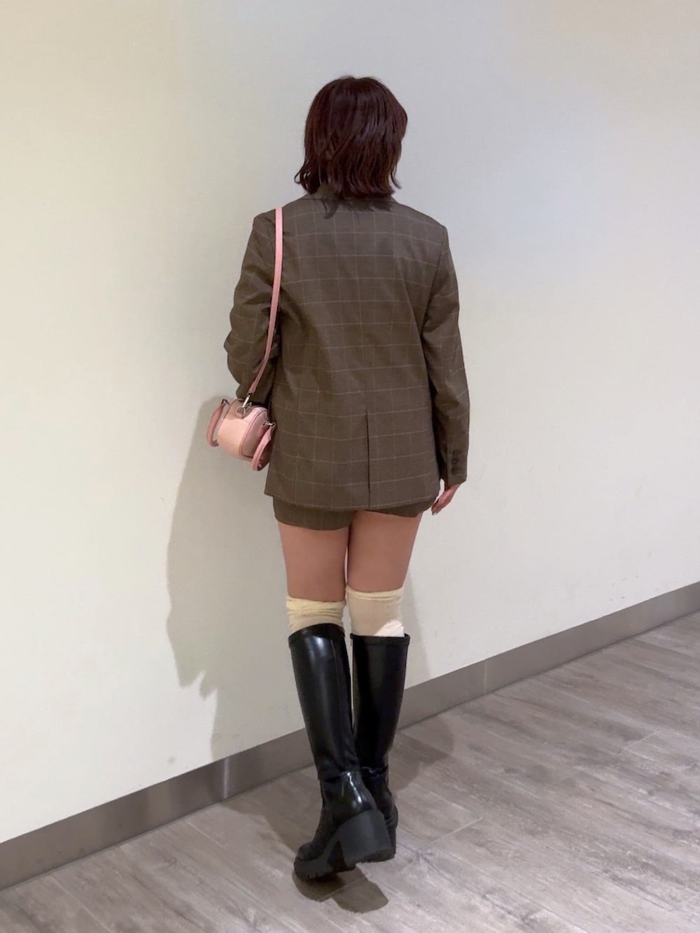 ブラウン系のテーラードジャケット、ブラウン系のその他パンツ、ピンク系のボストンバッグを着用したレディースの冬コーディネートの4枚目の写真