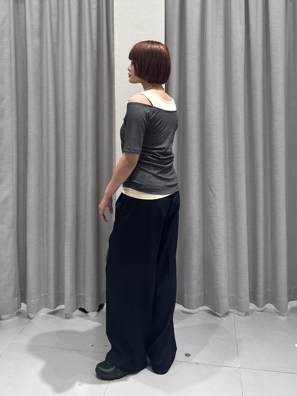 ブラウン系のショルダーバッグ、ブルー系のスラックス、グレー系のTシャツ/カットソーを着用したレディースの夏コーディネートの3枚目の写真