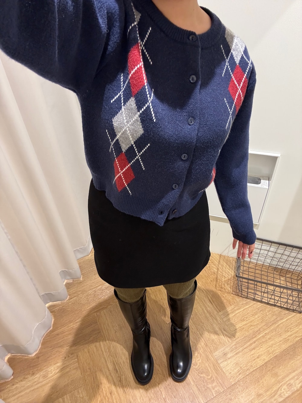 ブラック系のスカート、ブルー系のニット/セーター、ブラック系のブーツを着用したレディースの秋コーディネートの4枚目の写真