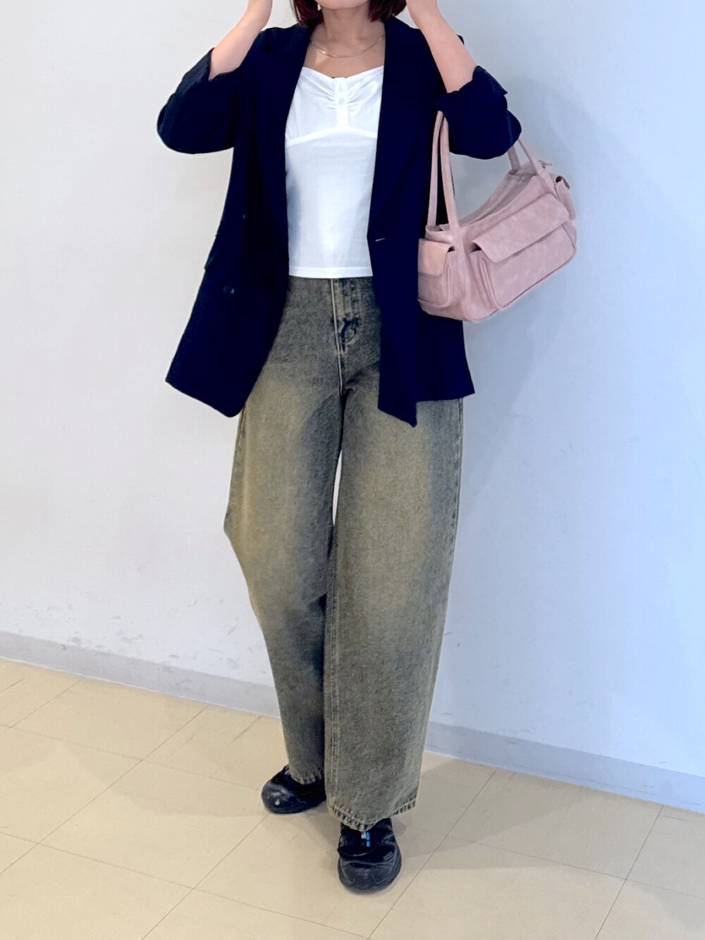 ピンク系のショルダーバッグ、ブルー系のデニムパンツ、ホワイト系のTシャツ/カットソーを着用したレディースの春コーディネートの4枚目の写真