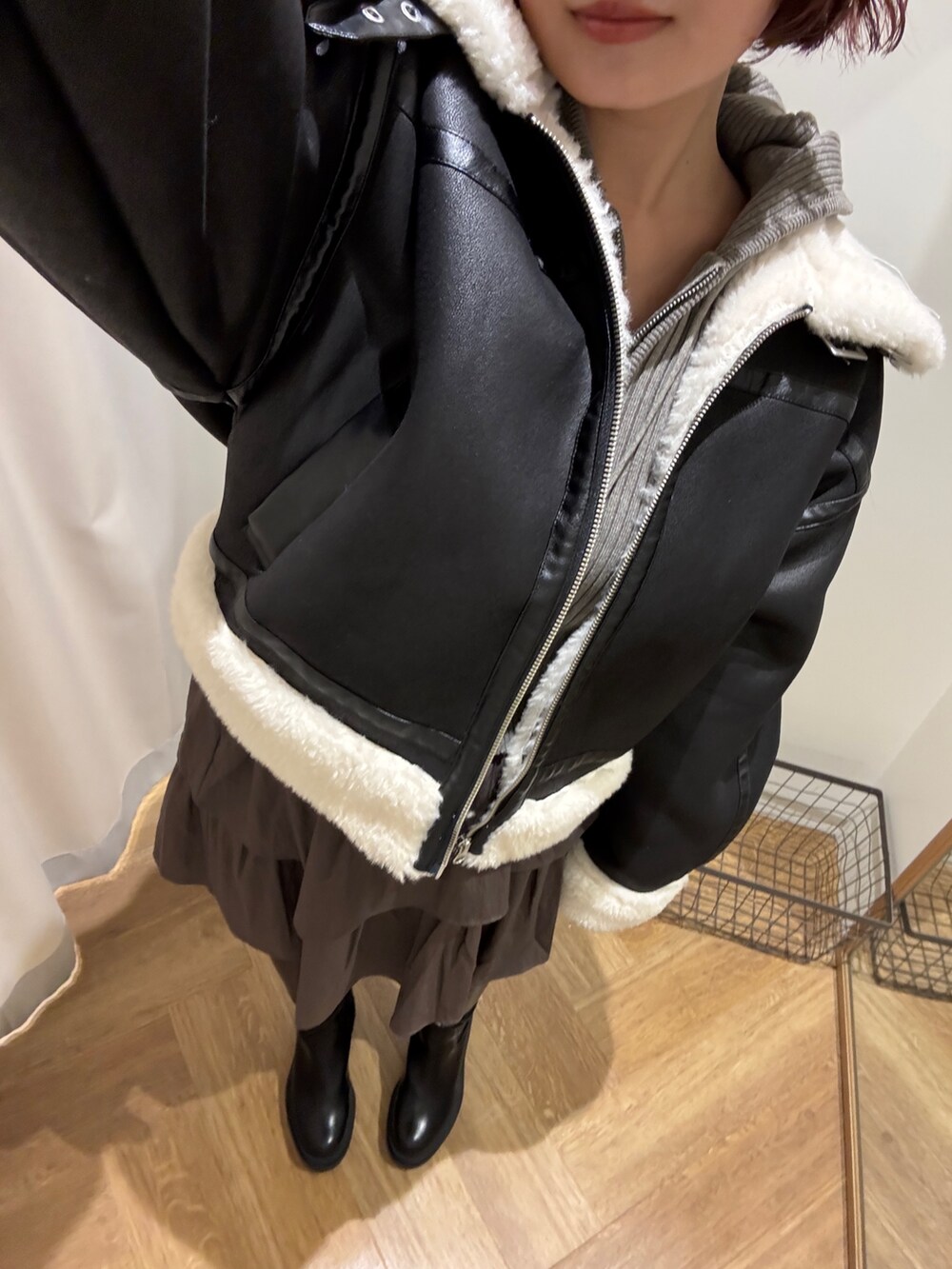 ブラック系のブルゾン、ブラック系のブーツ、ブラウン系のスカートを着用したレディースの冬コーディネートの5枚目の写真