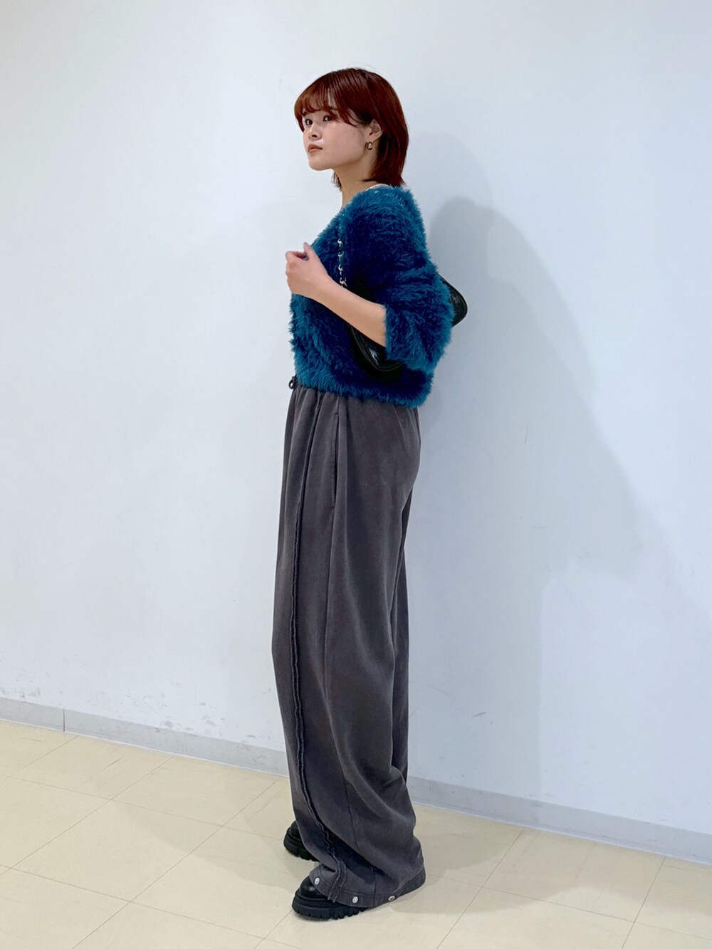 ブラック系のブーツ、グリーン系のカーディガン/ボレロ、ブラック系のトートバッグを着用したレディースの秋コーディネートの5枚目の写真