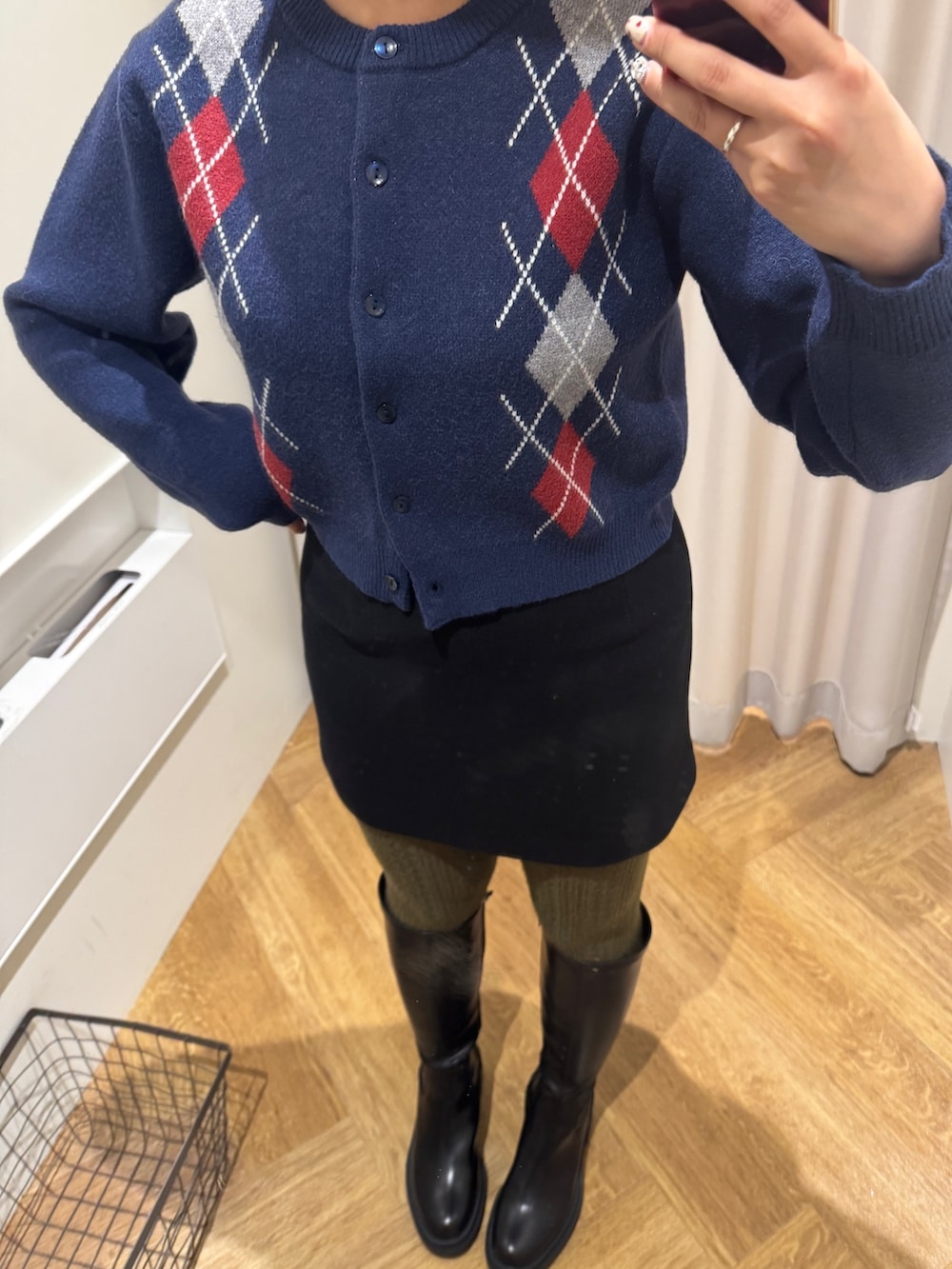 ブラック系のスカート、ブルー系のニット/セーター、ブラック系のブーツを着用したレディースの秋コーディネートの2枚目の写真