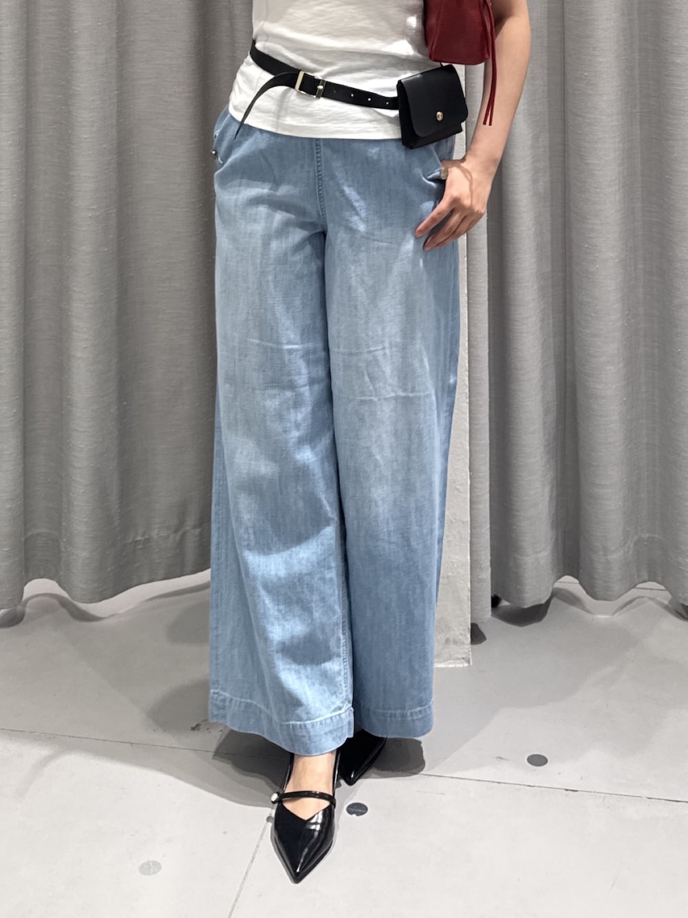 ブルー系のデニムパンツ、ホワイト系のTシャツ/カットソー、レッド系のショルダーバッグを着用したレディースの夏コーディネートの4枚目の写真