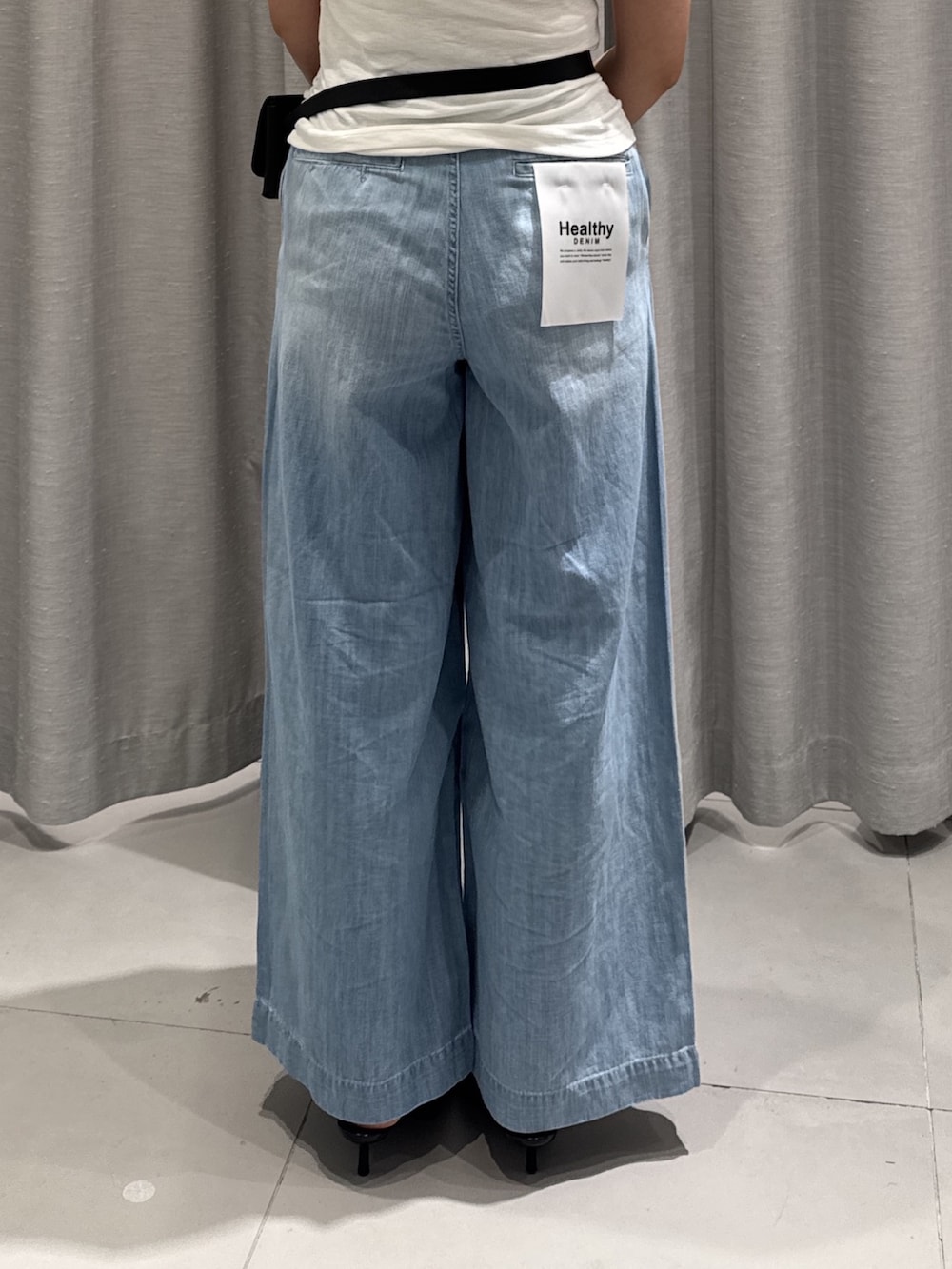 ブルー系のデニムパンツ、ホワイト系のTシャツ/カットソー、レッド系のショルダーバッグを着用したレディースの夏コーディネートの3枚目の写真