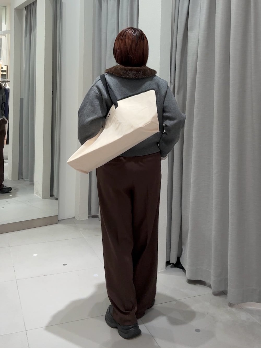ブラウン系のスラックス、グレー系のカーディガン/ボレロ、ホワイト系のTシャツ/カットソーを着用したレディースの秋コーディネートの4枚目の写真