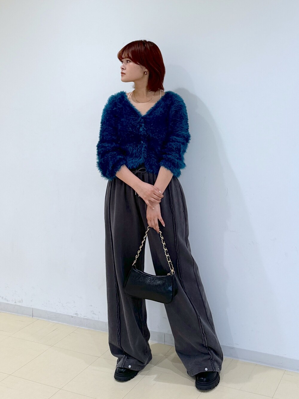 ブラック系のブーツ、グリーン系のカーディガン/ボレロ、ブラック系のトートバッグを着用したレディースの秋コーディネートの6枚目の写真