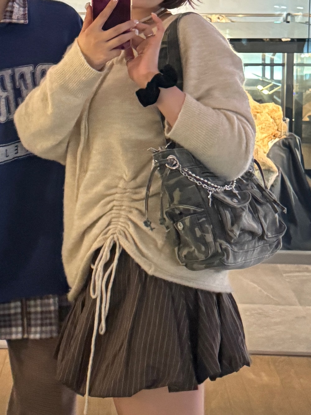 ブラウン系のスカート、ブラック系のブーツ、ベージュ系のニット/セーターを着用したレディースの冬コーディネートの3枚目の写真