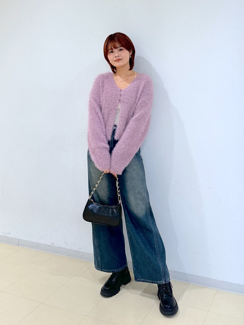 ブルー系のデニムパンツ、ブラック系のトートバッグ、ブラック系のブーツを着用したレディースの秋コーディネートの5枚目の写真