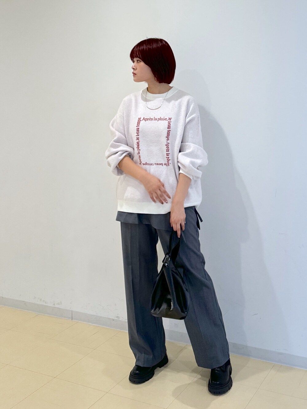 グレー系のその他パンツ、ブラック系のハンドバッグ、ゴールド系のネックレスを着用したレディースの秋コーディネートの2枚目の写真