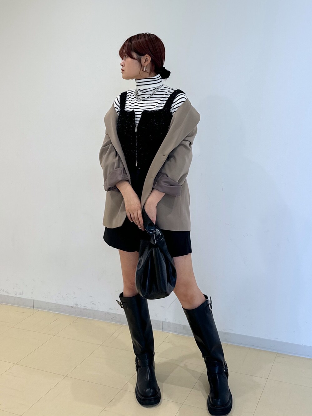 ブラック系のその他パンツ、ブラック系のハンドバッグ、ブラック系のブーツを着用したレディースの秋コーディネートの4枚目の写真