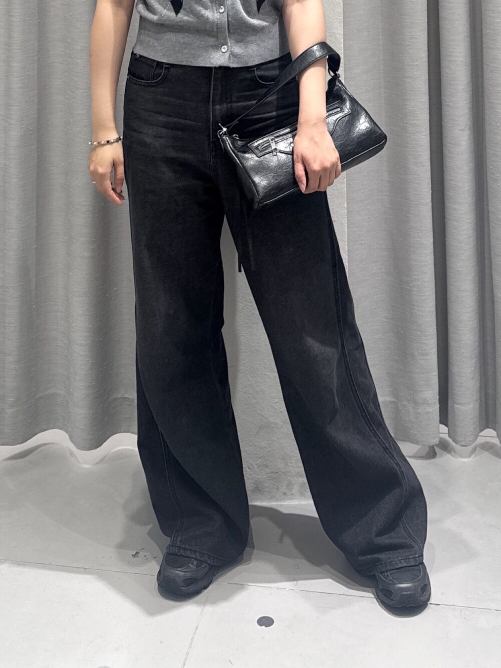ブラック系のデニムパンツ、ブラック系のショルダーバッグ、グレー系のカーディガン/ボレロを着用したレディースの夏コーディネートの3枚目の写真