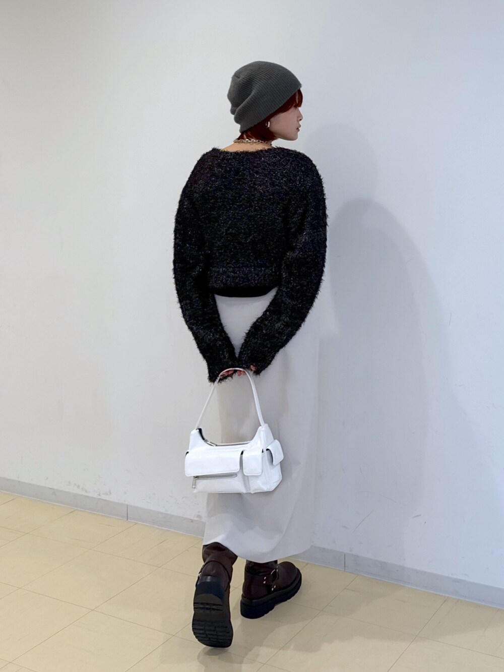 グリーン系のブルゾン、ホワイト系のハンドバッグ、ブラウン系のブーツを着用したレディースの冬コーディネートの6枚目の写真