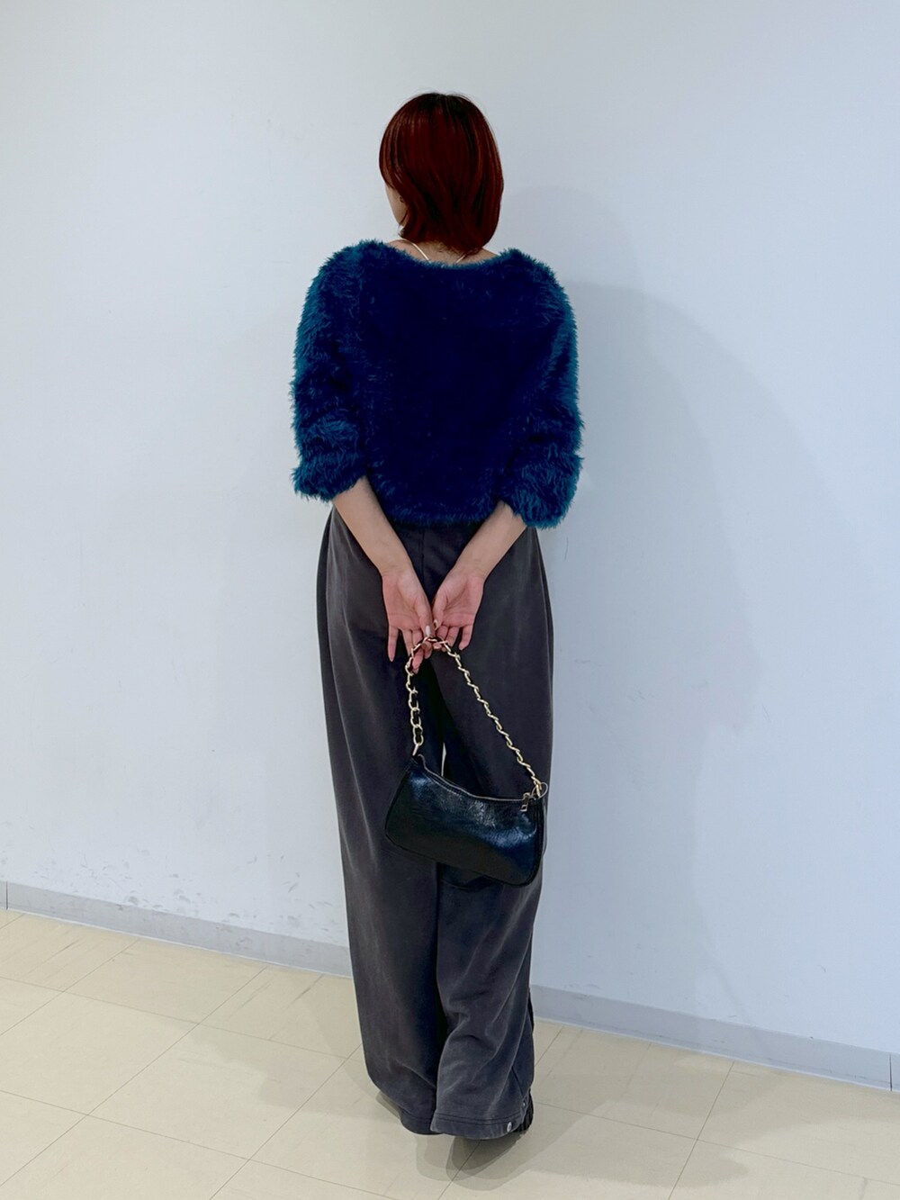 ブラック系のブーツ、グリーン系のカーディガン/ボレロ、ブラック系のトートバッグを着用したレディースの秋コーディネートの4枚目の写真