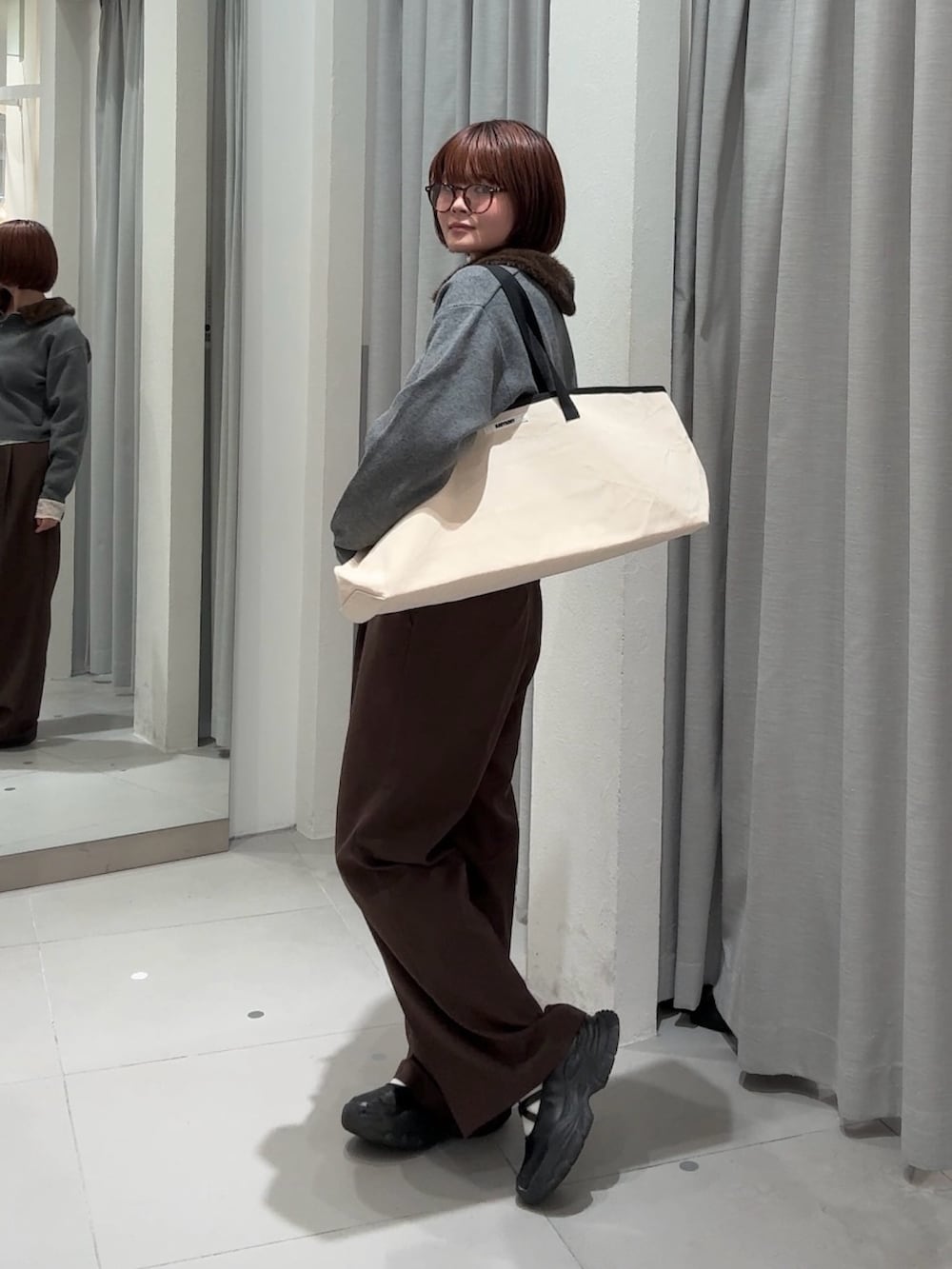 ブラウン系のスラックス、グレー系のカーディガン/ボレロ、ホワイト系のTシャツ/カットソーを着用したレディースの秋コーディネートの5枚目の写真
