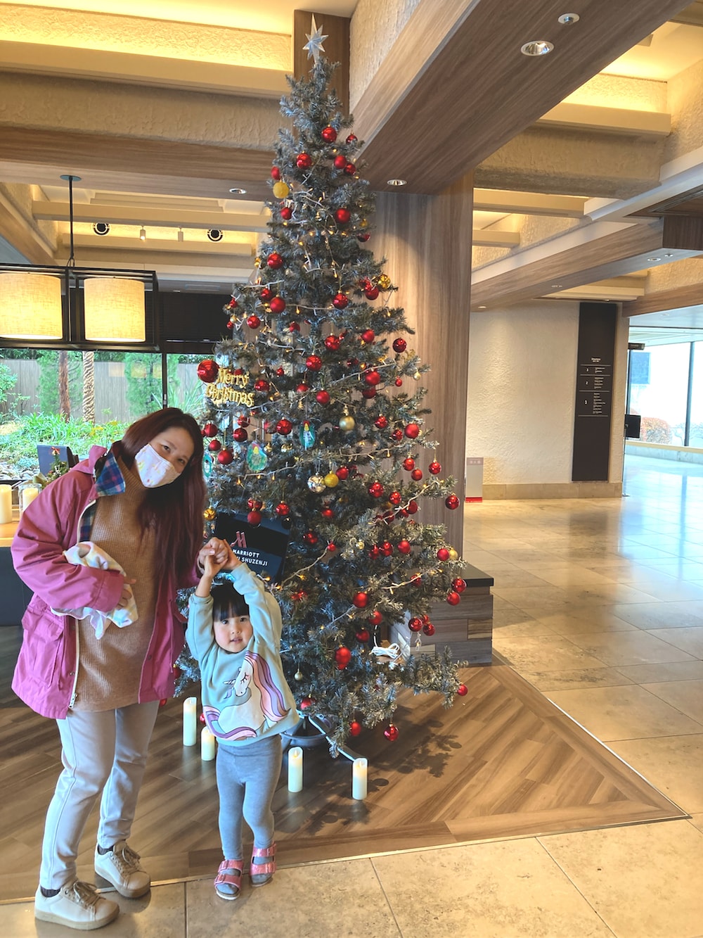 オレンジ系のニット/セーター、ブルー系のパーカー、ベージュ系のスウェットパンツを着用したレディースの冬コーディネートの2枚目の写真