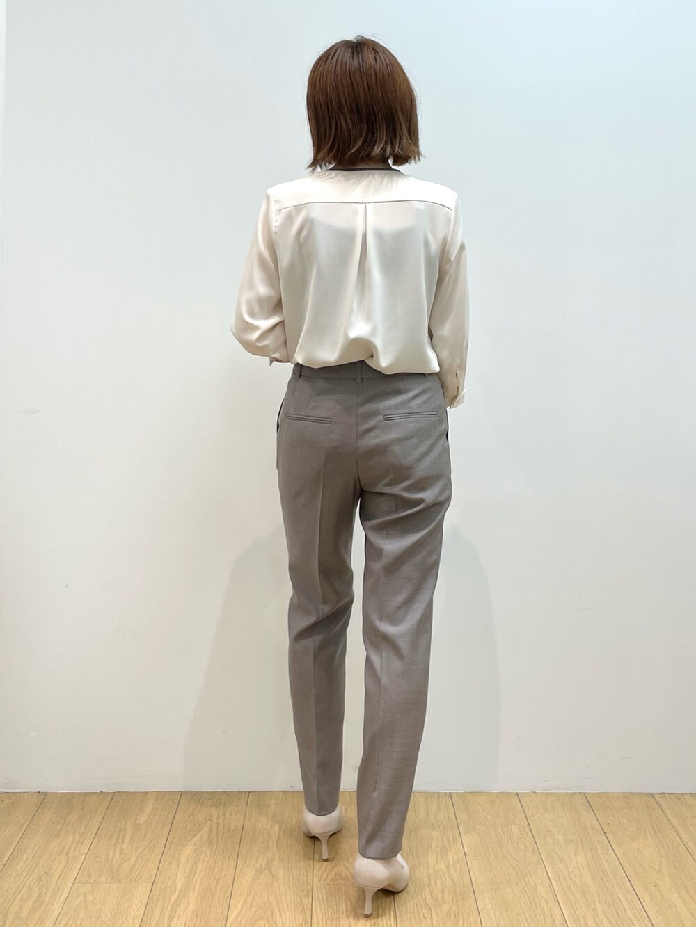 ホワイト系のシャツ/ブラウス、ベージュ系のパンプス、ブラウン系のその他パンツを着用したレディースの秋コーディネートの2枚目の写真