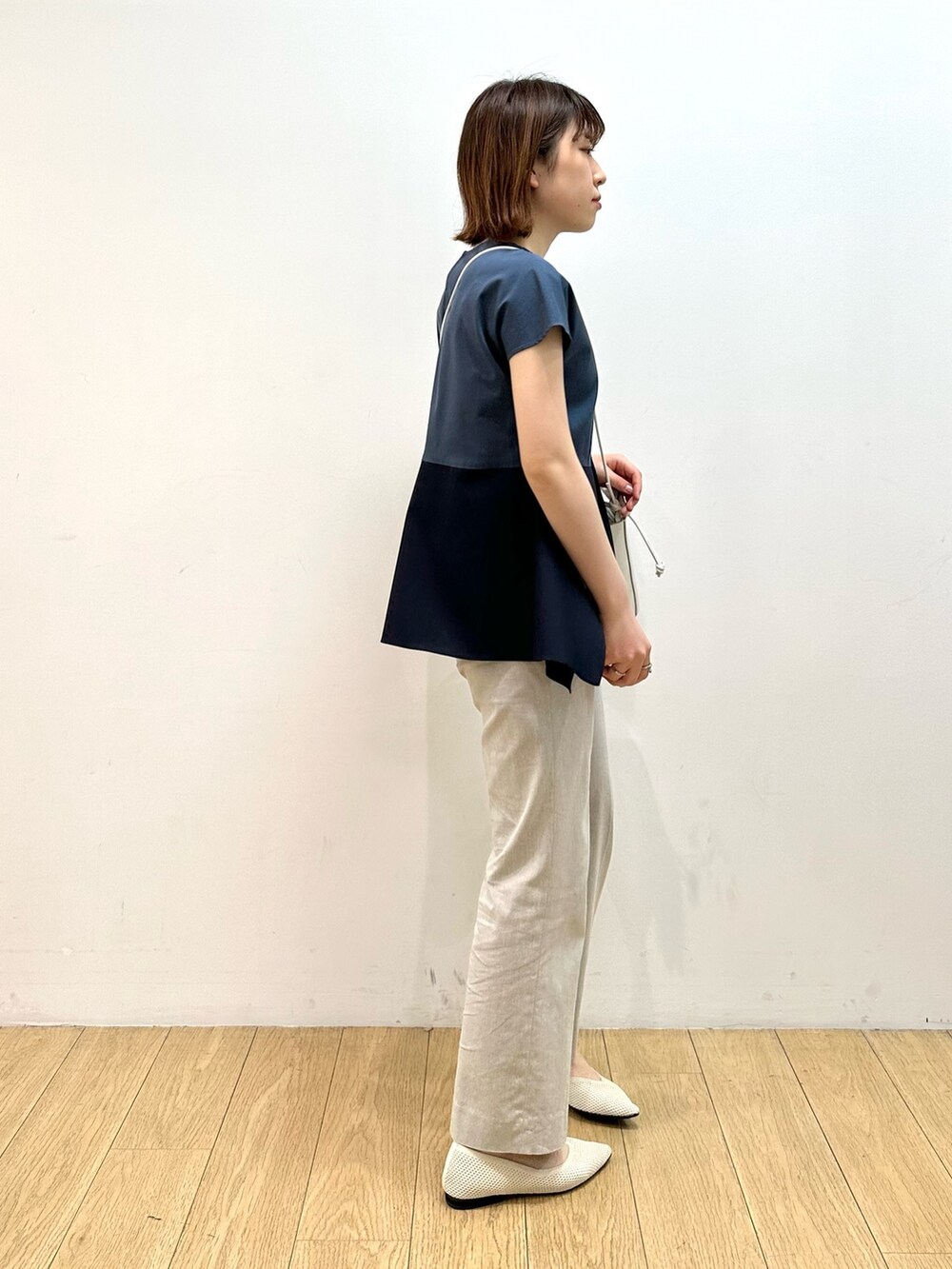 ブルー系のシャツ/ブラウス、ホワイト系のショルダーバッグ、ベージュ系のパンプスを着用したレディースの春コーディネートの2枚目の写真