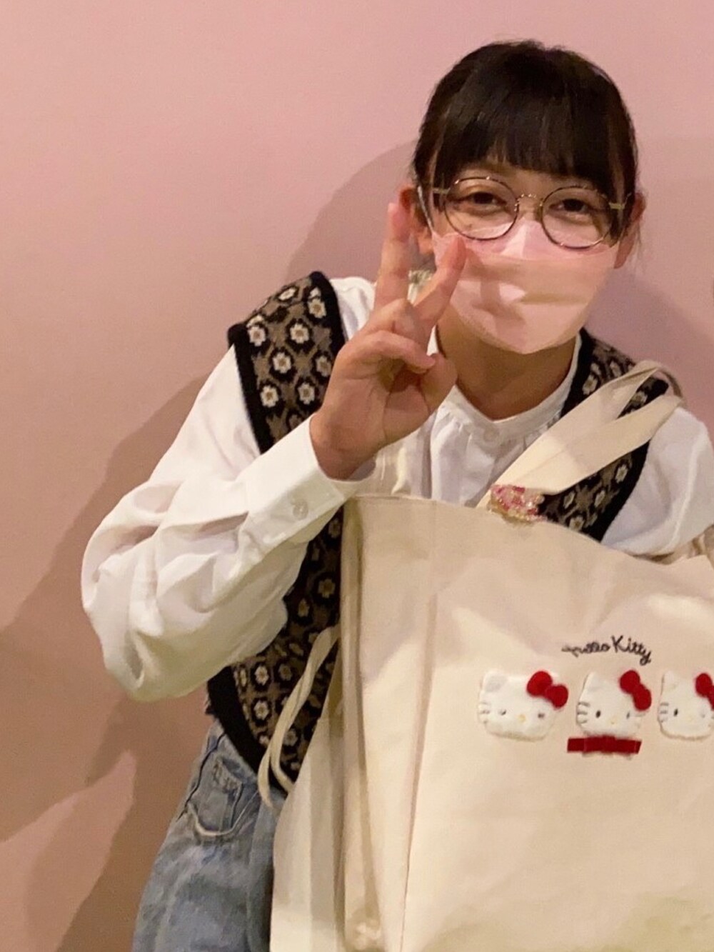 ブルー系のデニムパンツ、ブラック系のベストを着用したレディースの冬コーディネートの2枚目の写真