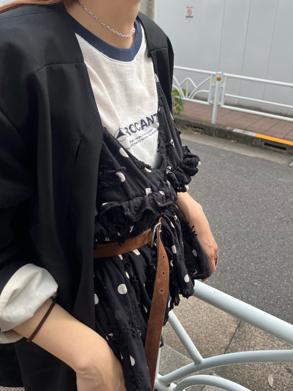 ブラック系のノーカラージャケット、ホワイト系のTシャツ/カットソー、ブラック系のスカートを着用したレディースの秋コーディネートの3枚目の写真