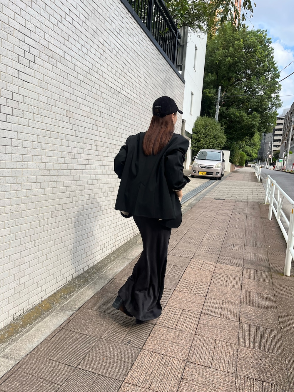 ブラック系のノーカラージャケット、ホワイト系のTシャツ/カットソー、ブラック系のスカートを着用したレディースの秋コーディネートの2枚目の写真