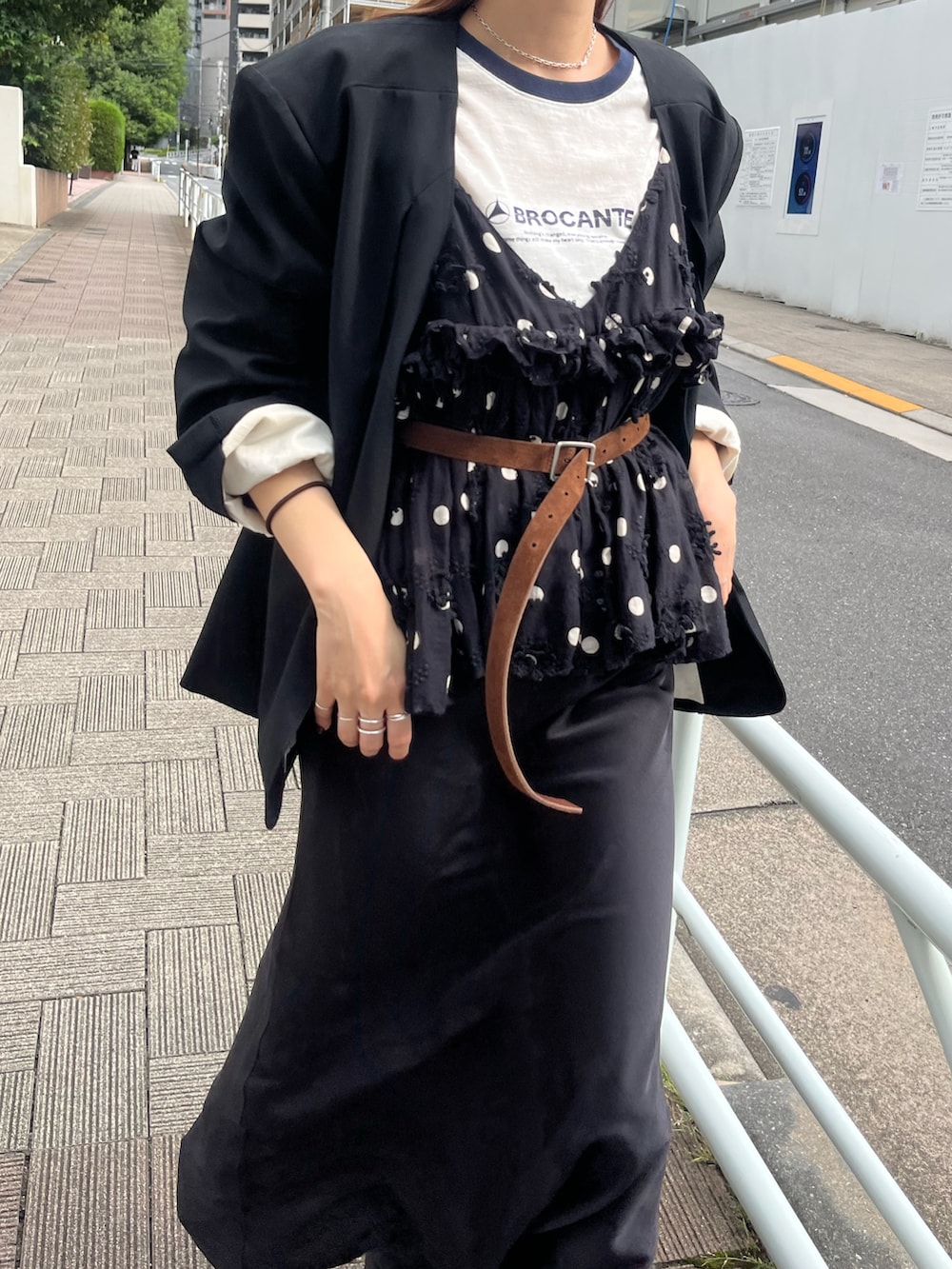 ブラック系のノーカラージャケット、ホワイト系のTシャツ/カットソー、ブラック系のスカートを着用したレディースの秋コーディネートの4枚目の写真