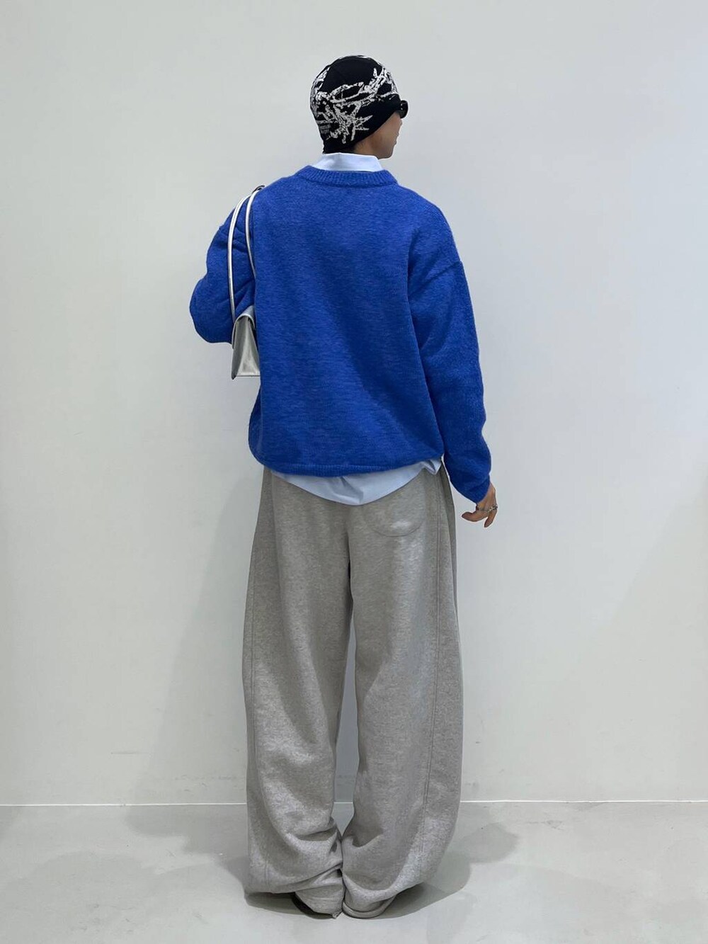 シルバー系のショルダーバッグ、ブルー系のニット/セーターを着用したメンズの冬コーディネートの3枚目の写真