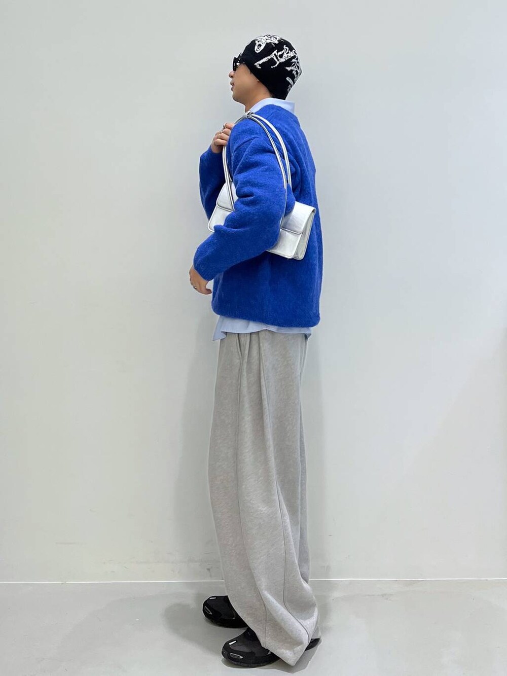 シルバー系のショルダーバッグ、ブルー系のニット/セーターを着用したメンズの冬コーディネートの2枚目の写真