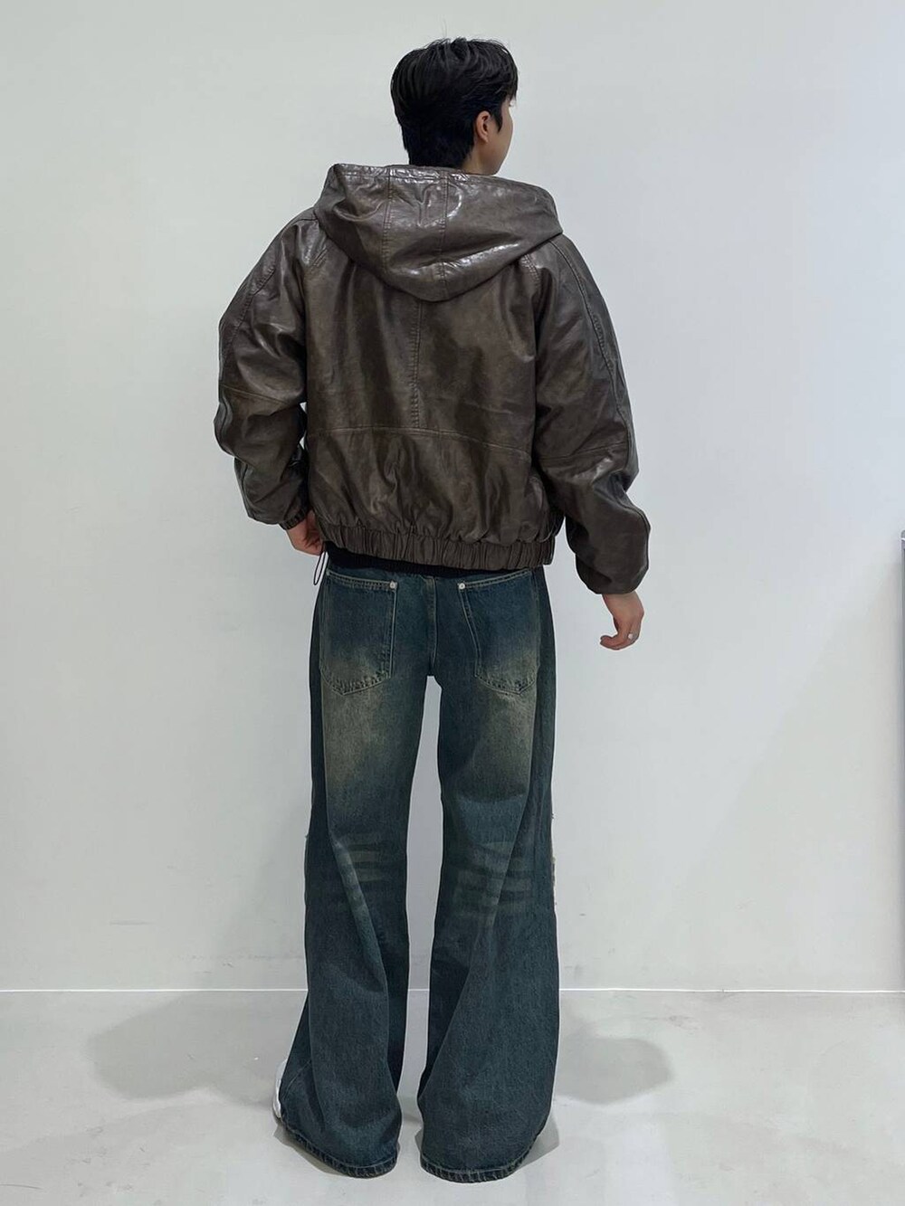 ブラック系のカーディガン/ボレロ、ブラウン系のブルゾン、ブルー系のその他パンツを着用したメンズの冬コーディネートの2枚目の写真