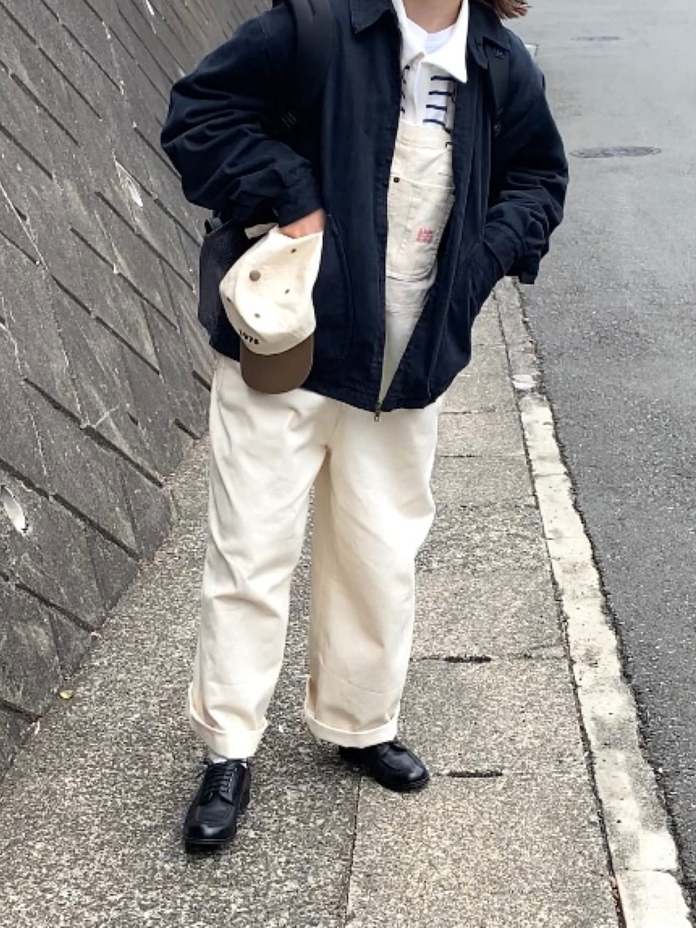 ホワイト系のサロペット/オーバーオール、ブルー系のTシャツ/カットソー、ブラック系のドレスシューズを着用したレディースの春コーディネートの3枚目の写真