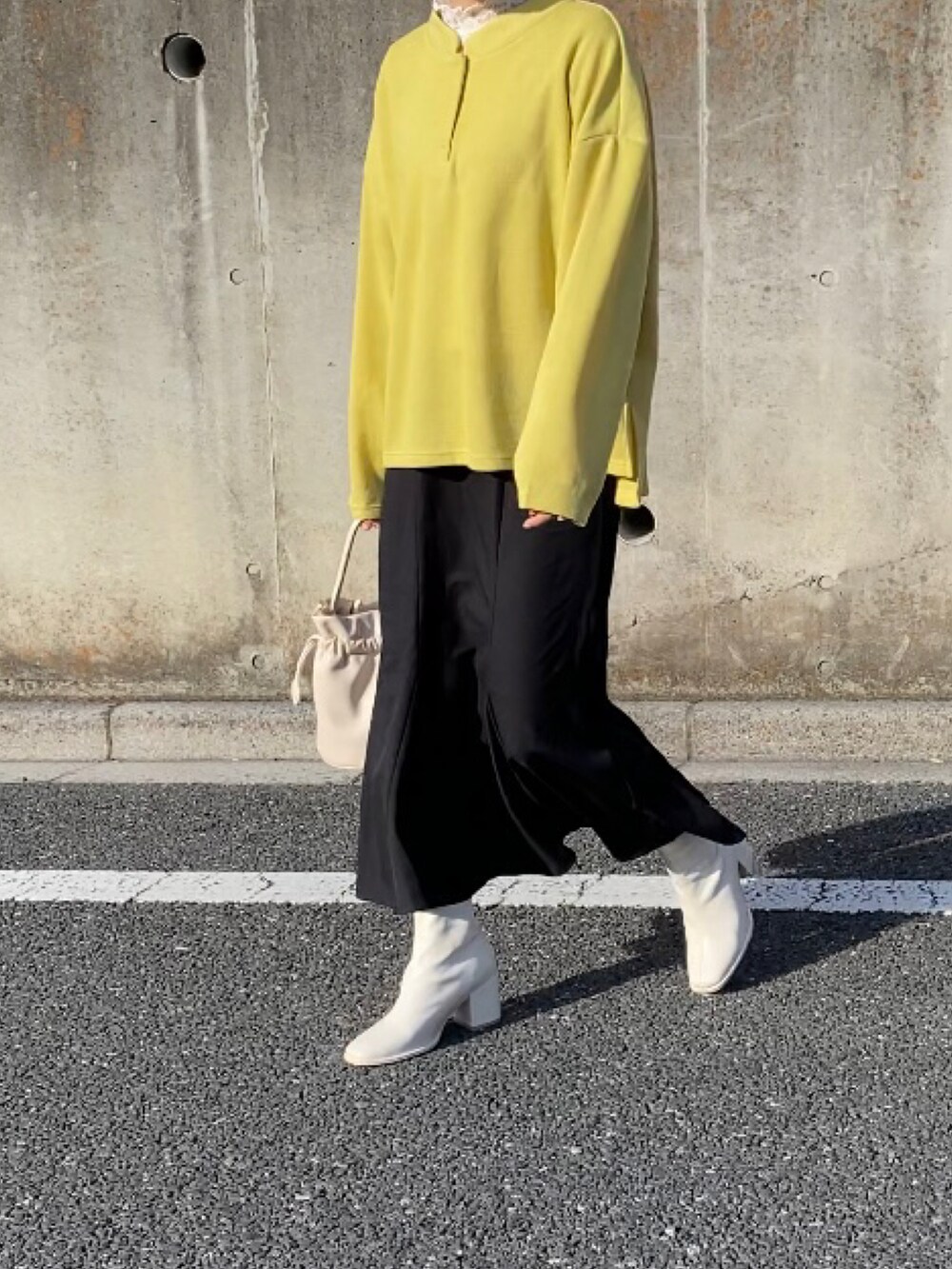 ベージュ系のショルダーバッグ、イエロー系のスウェット、ホワイト系のトップスを着用したレディースの春コーディネートの2枚目の写真