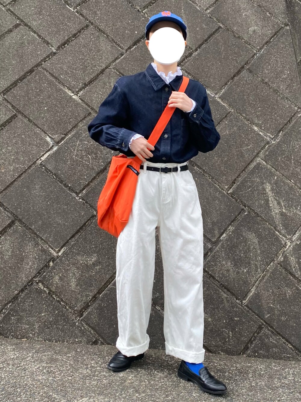 ブルー系のデニムジャケット、オレンジ系のショルダーバッグ、ブルー系のキャップを着用したレディースの春コーディネートの4枚目の写真