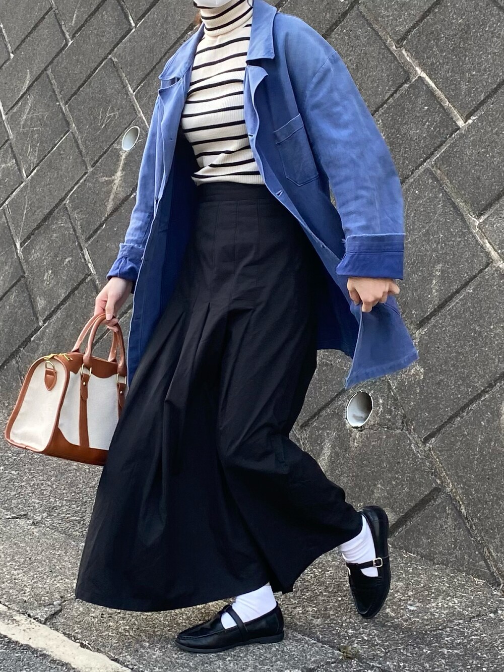 ベージュ系のボストンバッグ、ブラック系のローファー、ホワイト系のニット/セーターを着用したレディースの春コーディネートの4枚目の写真