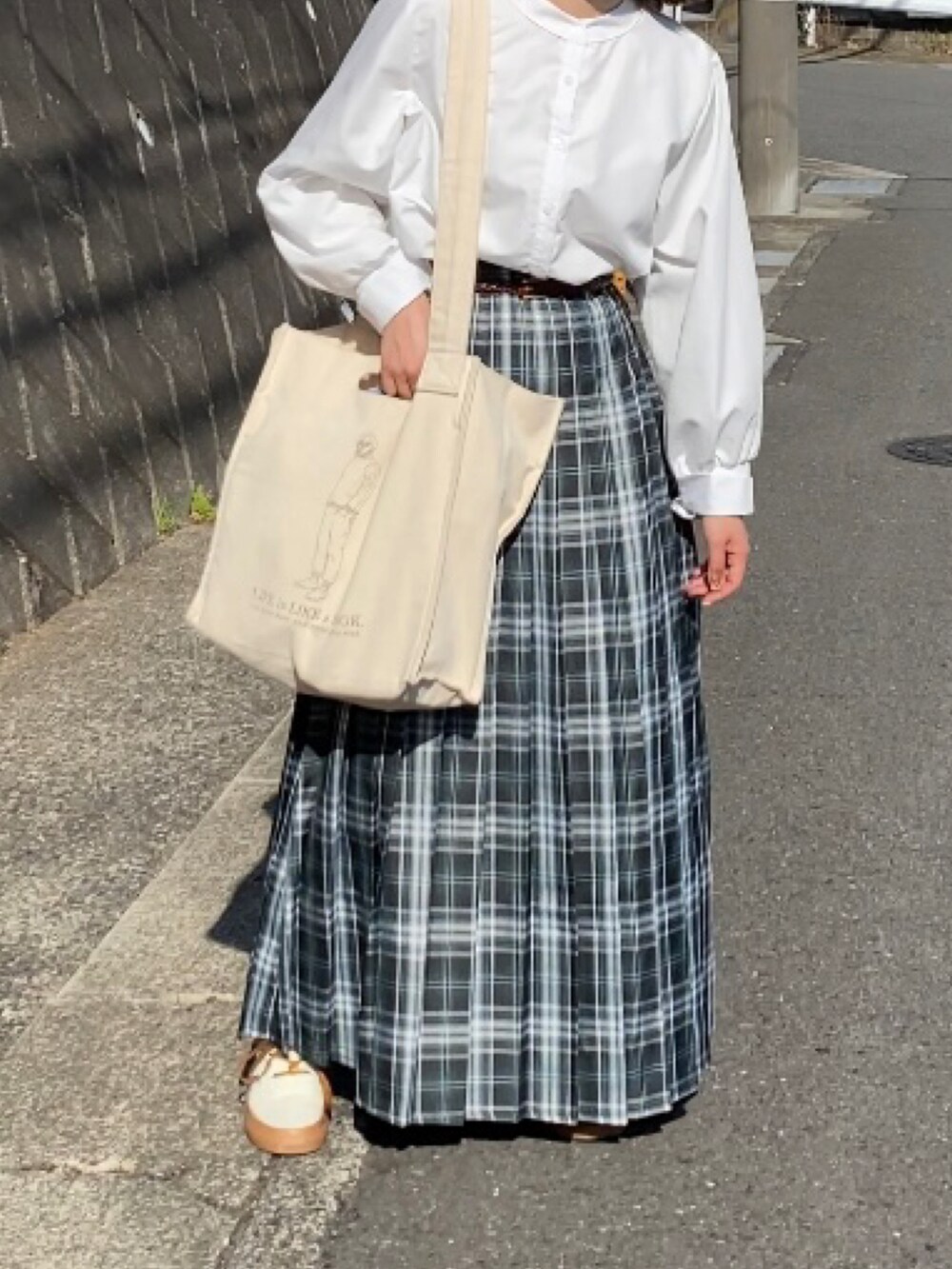 ベージュ系のスニーカー、ブルー系のスカート、ホワイト系のシャツ/ブラウスを着用したレディースの春コーディネートの3枚目の写真