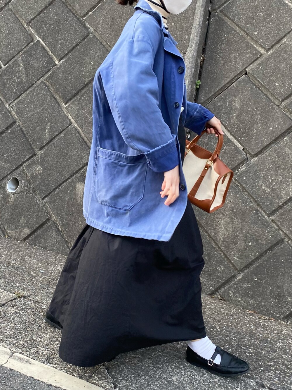 ベージュ系のボストンバッグ、ブラック系のローファー、ホワイト系のニット/セーターを着用したレディースの春コーディネートの3枚目の写真