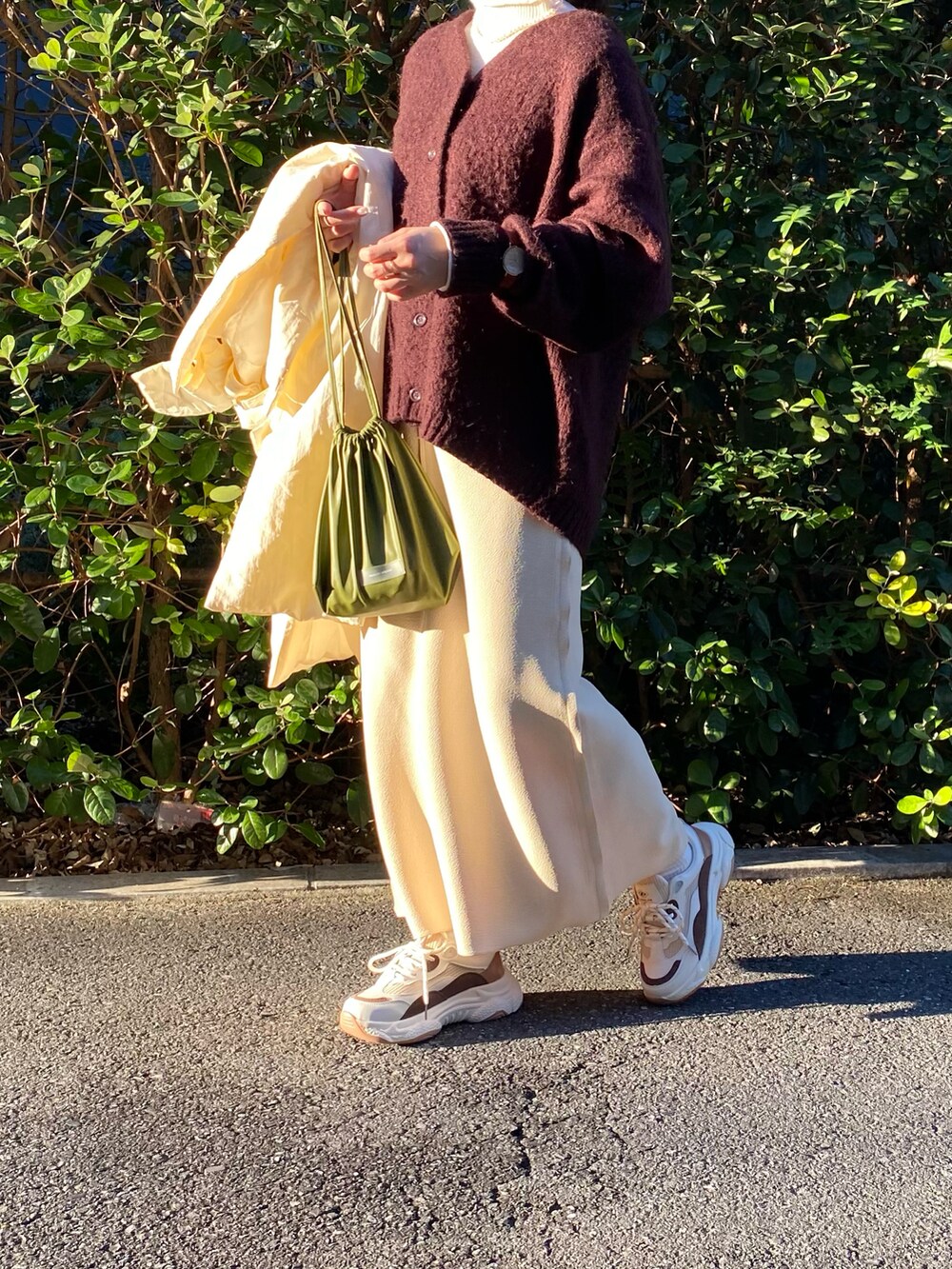 ホワイト系のダウンジャケット/コート、ブラウン系のカーディガン/ボレロ、グリーン系のショルダーバッグを着用したレディースの冬コーディネートの3枚目の写真