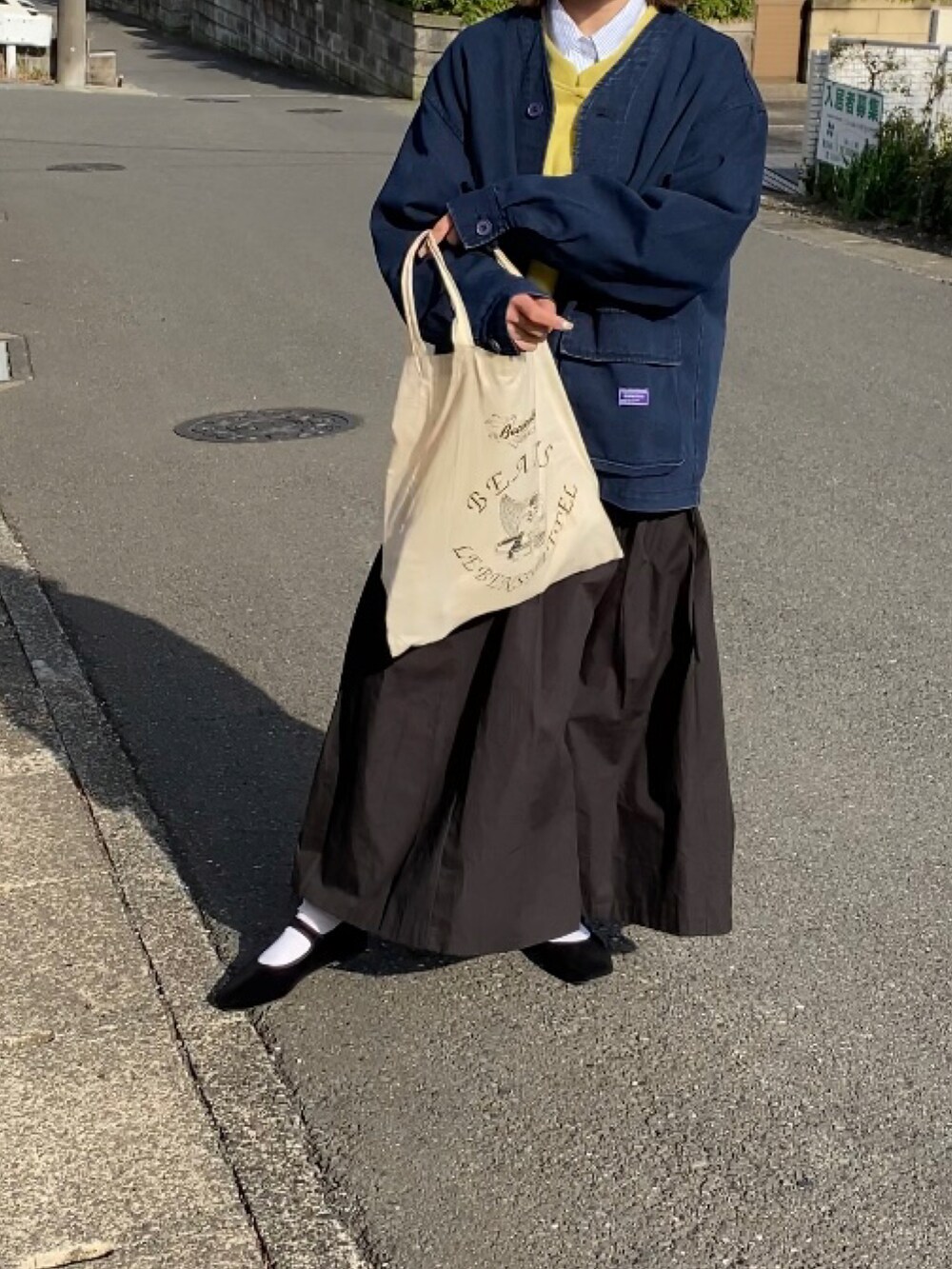 ブルー系のカバーオール、イエロー系のスウェット、ブルー系のシャツ/ブラウスを着用したレディースの春コーディネートの2枚目の写真