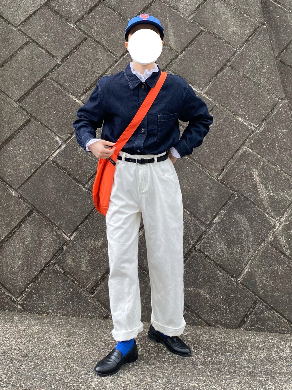 ブルー系のデニムジャケット、オレンジ系のショルダーバッグ、ブルー系のキャップを着用したレディースの春コーディネートの2枚目の写真