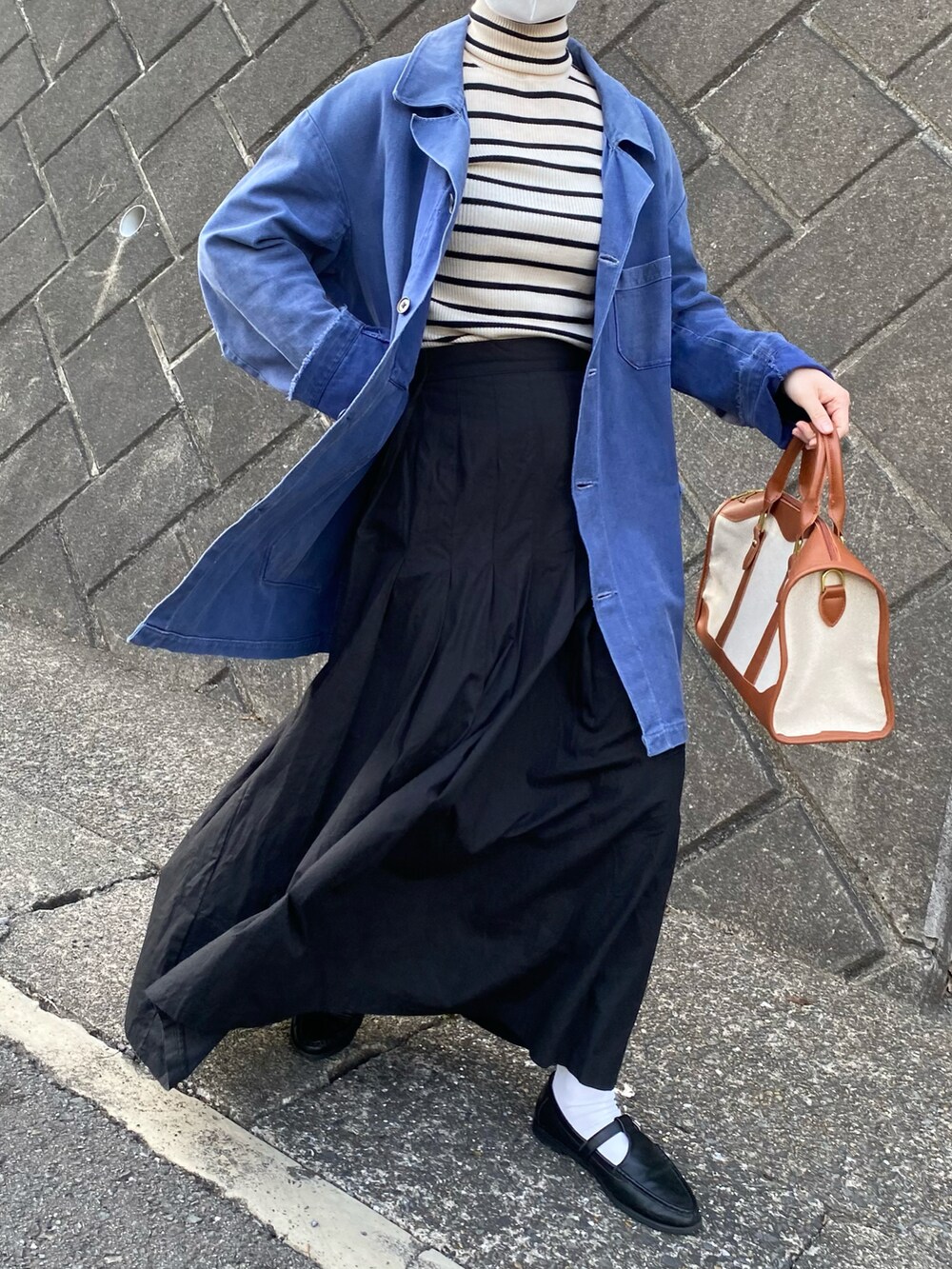 ベージュ系のボストンバッグ、ブラック系のローファー、ホワイト系のニット/セーターを着用したレディースの春コーディネートの2枚目の写真