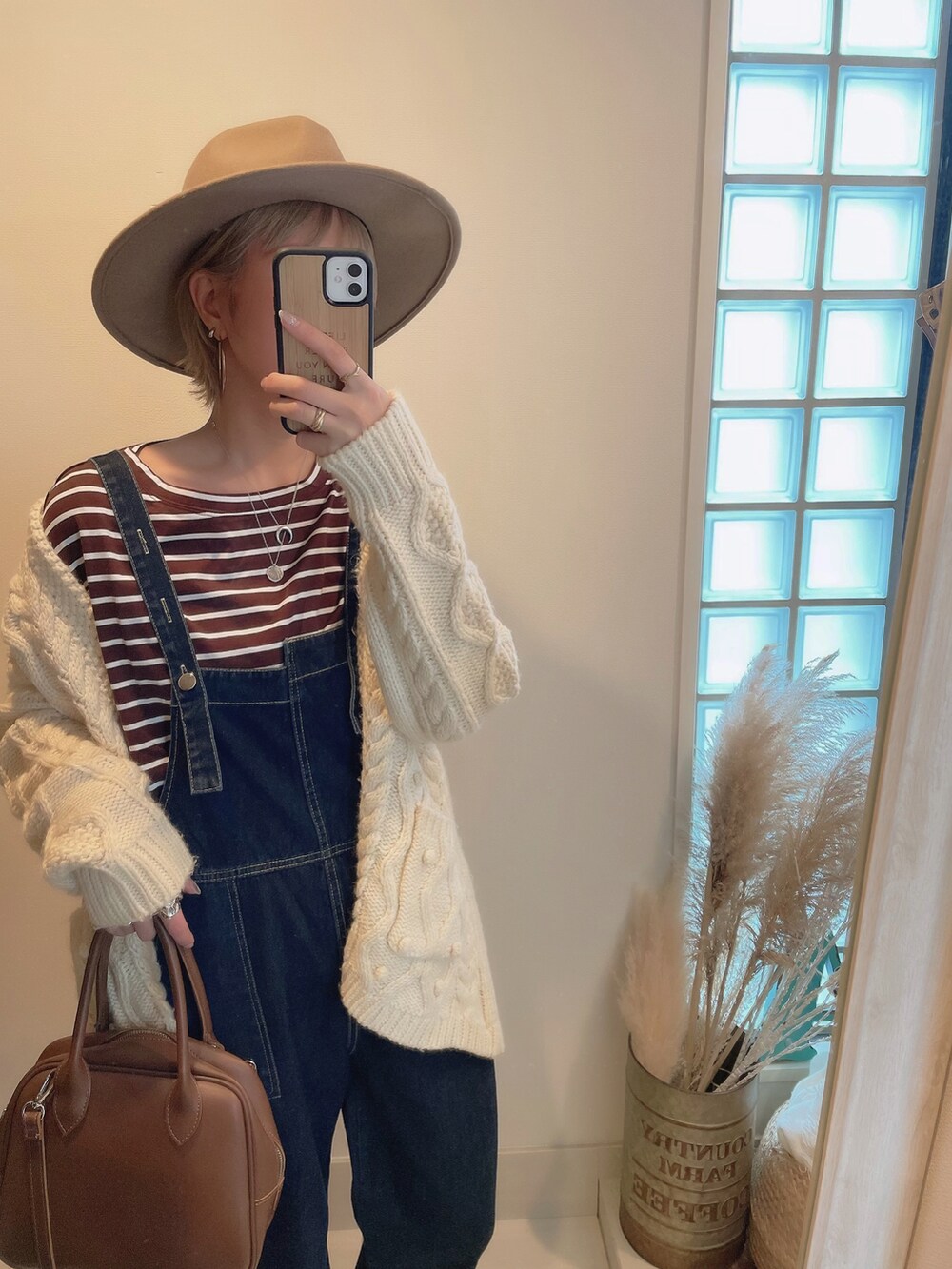 ホワイト系のカーディガン/ボレロ、ブラウン系のショルダーバッグ、ブラウン系のハットを着用したレディースの冬コーディネートの3枚目の写真