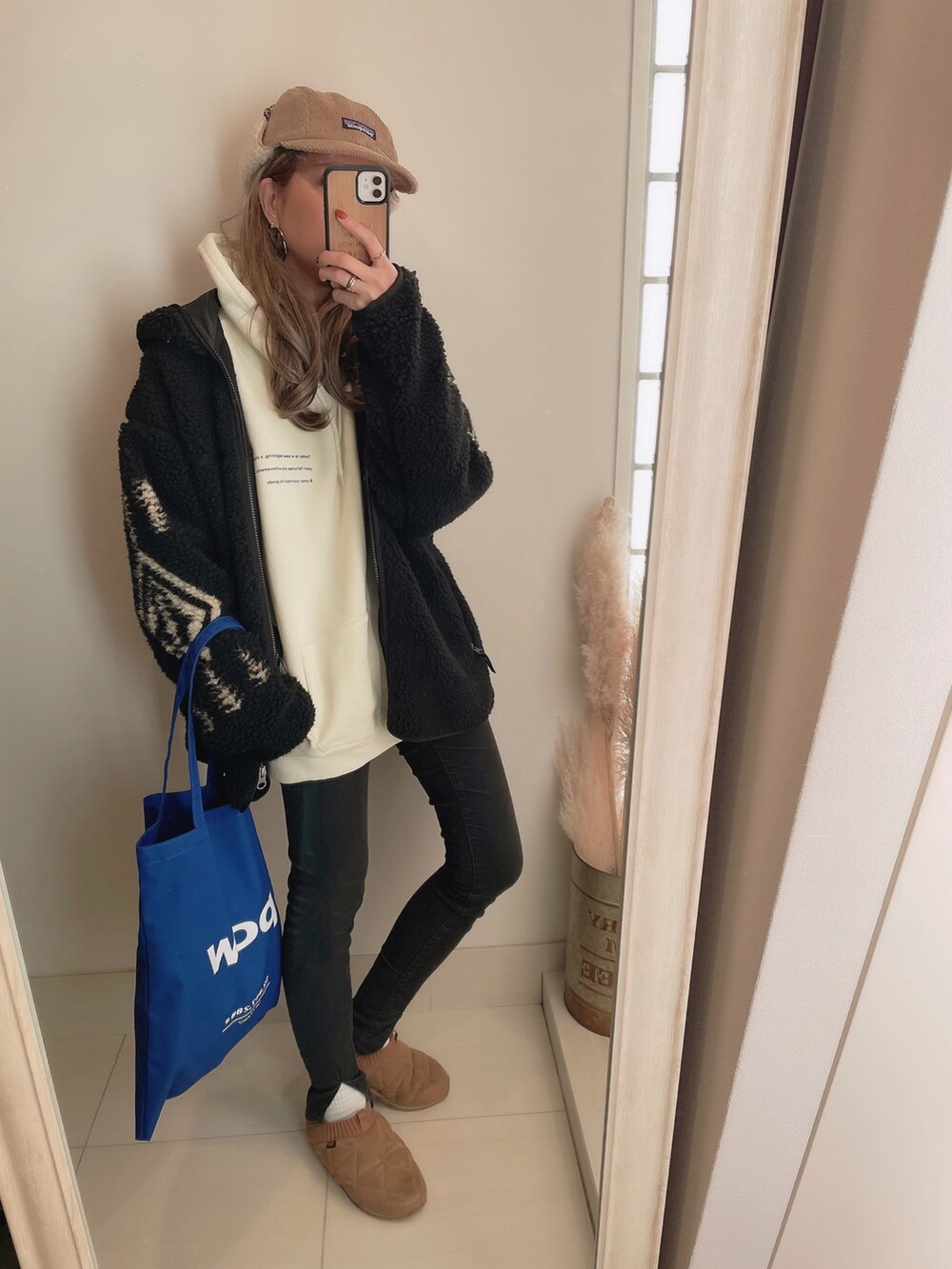 ブラック系のその他アウター、ホワイト系のパーカー、ブラック系のデニムパンツを着用したレディースの冬コーディネートの2枚目の写真