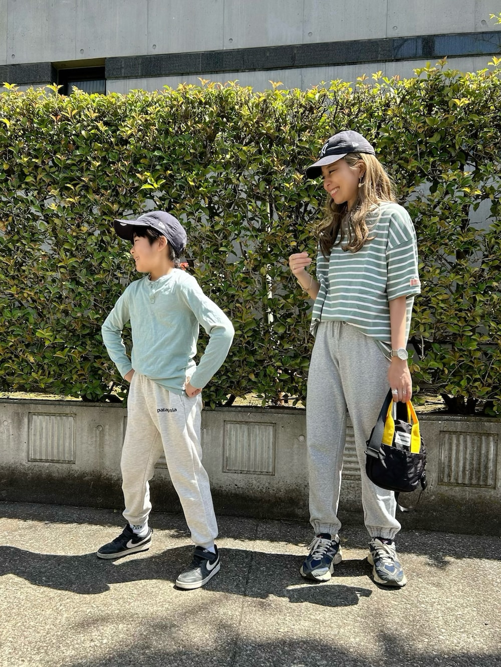 グリーン系のTシャツ/カットソー、ブラック系のトートバッグ、ブルー系のスニーカーを着用したレディースの春コーディネートの3枚目の写真