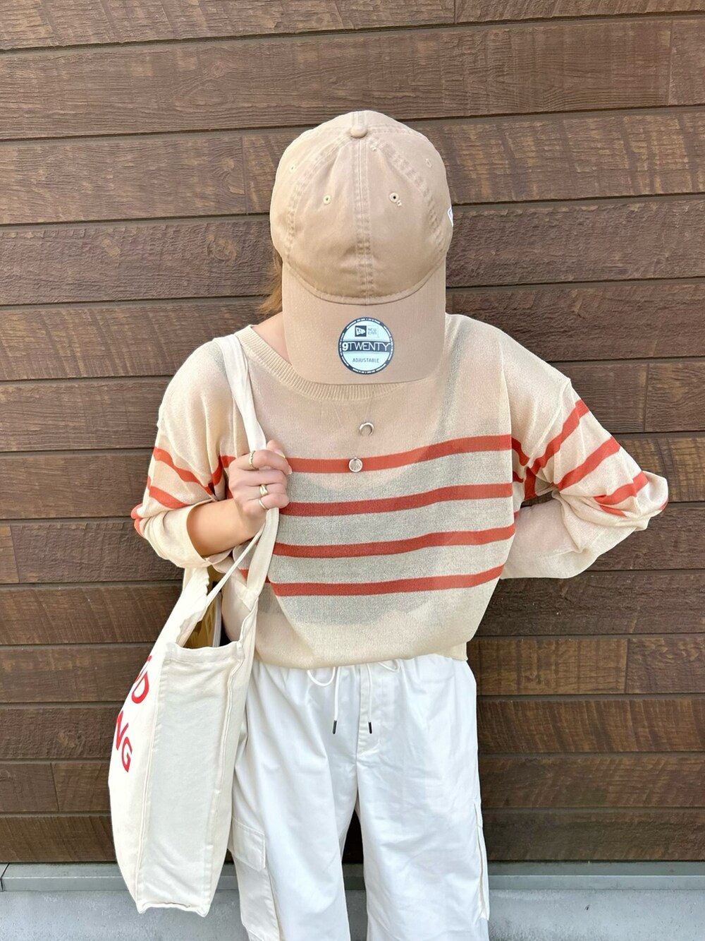 ベージュ系のTシャツ/カットソー、ブラック系のスニーカー、ホワイト系のパンツを着用したレディースの夏コーディネートの2枚目の写真