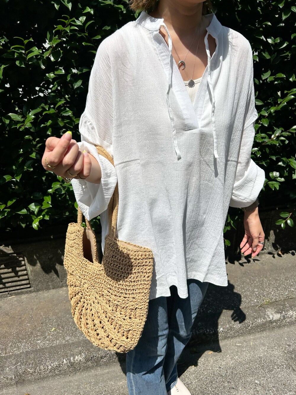 ホワイト系のシャツ/ブラウス、ブルー系のデニムパンツ、ホワイト系のサンダルを着用したレディースの夏コーディネートの3枚目の写真