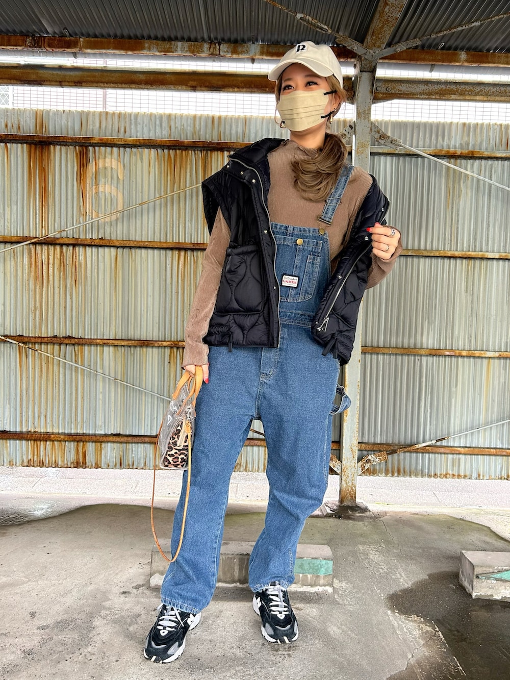 ブラウン系のTシャツ/カットソー、ブラック系のスニーカー、ベージュ系のショルダーバッグを着用したレディースの春コーディネートの2枚目の写真