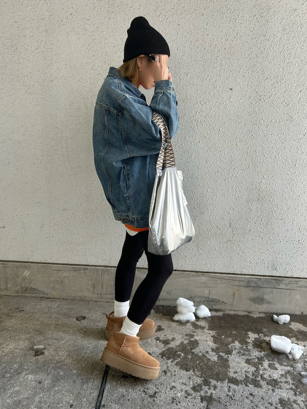 ブルー系のデニムジャケット、オレンジ系のスウェット、ブラウン系のブーツを着用したレディースの冬コーディネートの5枚目の写真