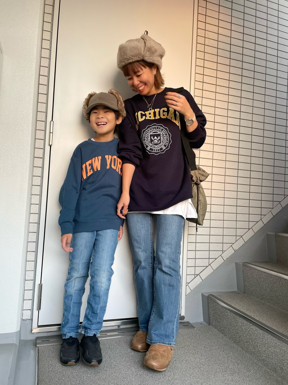 ブラウン系のスニーカー、グリーン系のショルダーバッグ、ブルー系のデニムパンツを着用したレディースの冬コーディネートの2枚目の写真