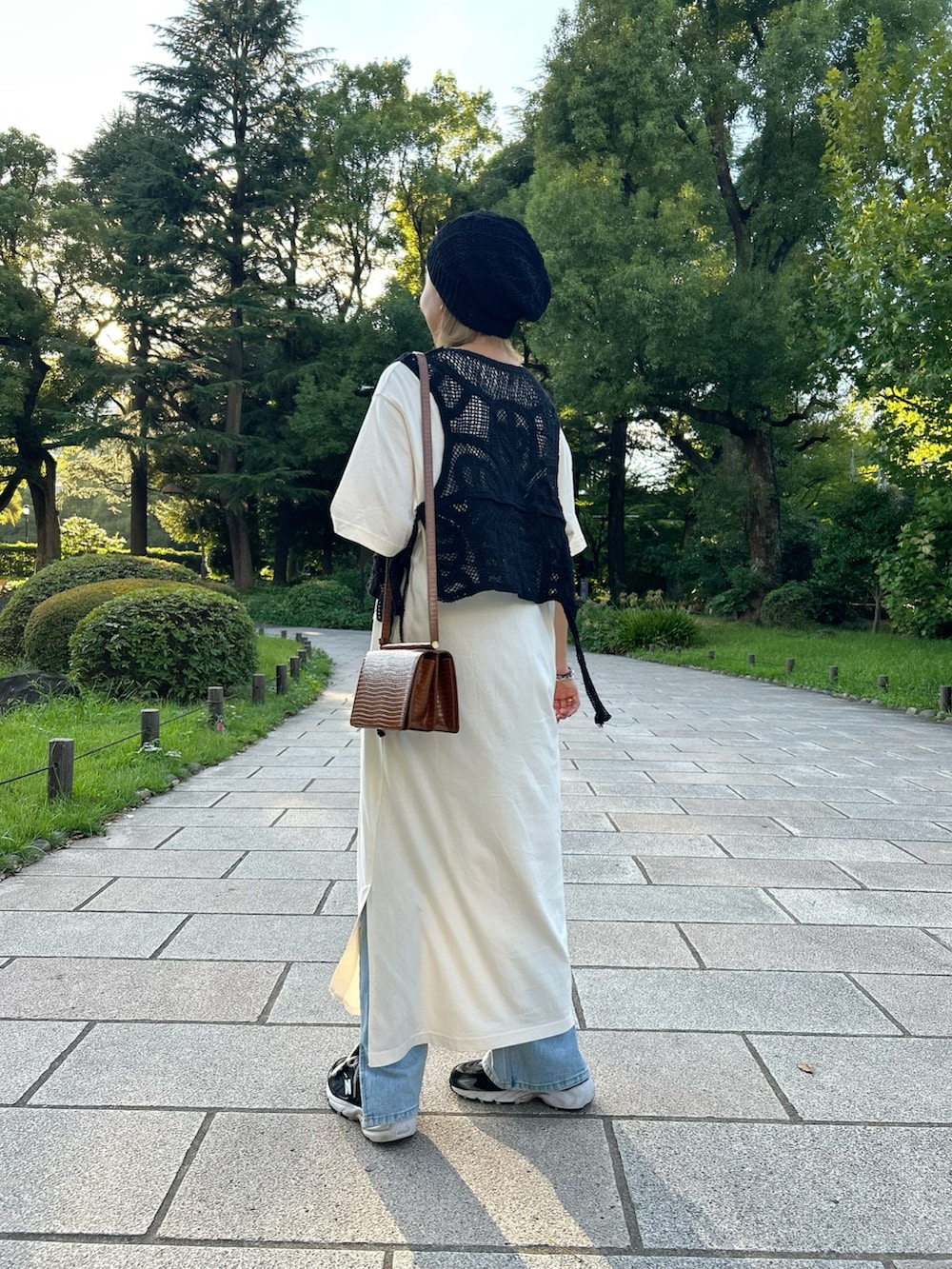 ブラック系のベスト、ブラック系のスニーカー、ブラック系のニットキャップ/ビーニーを着用したレディースの秋コーディネートの2枚目の写真