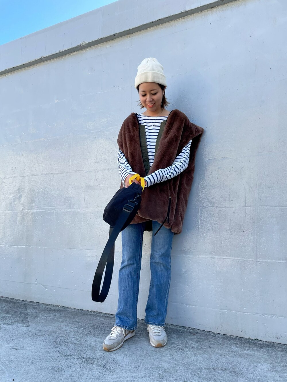 グリーン系のMA-1、ブラック系のトートバッグ、ベージュ系のスニーカーを着用したレディースの秋コーディネートの4枚目の写真