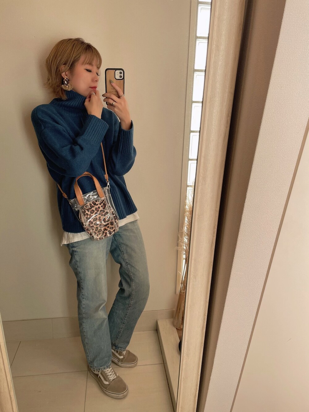 ブルー系のニット/セーター、ベージュ系のショルダーバッグ、ブルー系のデニムパンツを着用したレディースの秋コーディネートの2枚目の写真